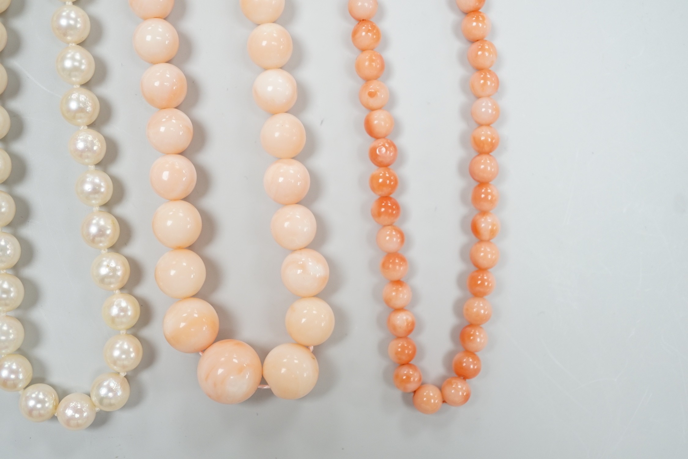 Two modern single strand cultured pearl necklaces, both with 375 clasp, one with hematite beads, longest 42cm, together with two modern coral bead necklaces, one with pair of matching drop earrings.